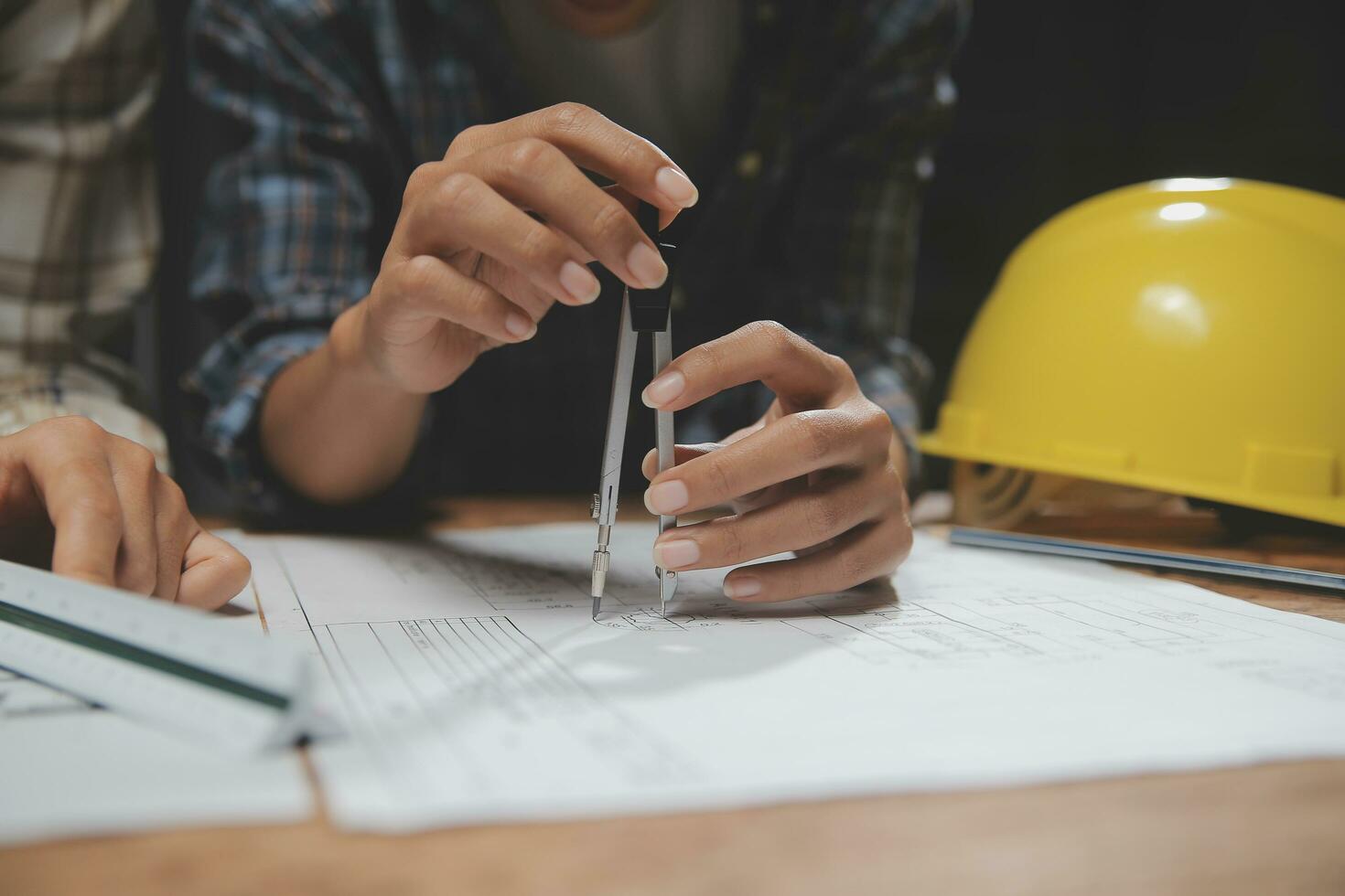 equipo de multiétnico arquitectos trabajando en construcción planes en reunión habitación. ingenieros que se discute en proyecto en oficina. maduro empresario y mujer en pie alrededor mesa trabajando en Plano. foto