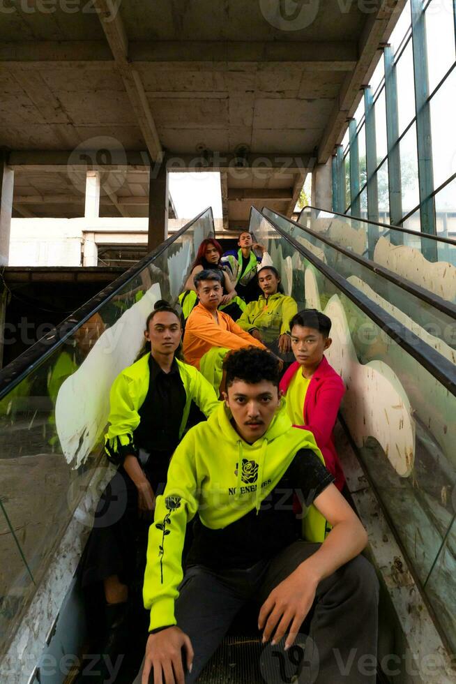 a group of Asian men are relaxing on the stairs with their friends at a university photo