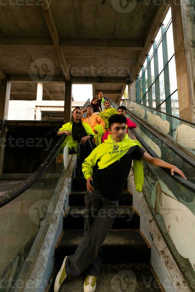 a group of Asian men in lemon green jackets are standing with their friends on the escalator photo