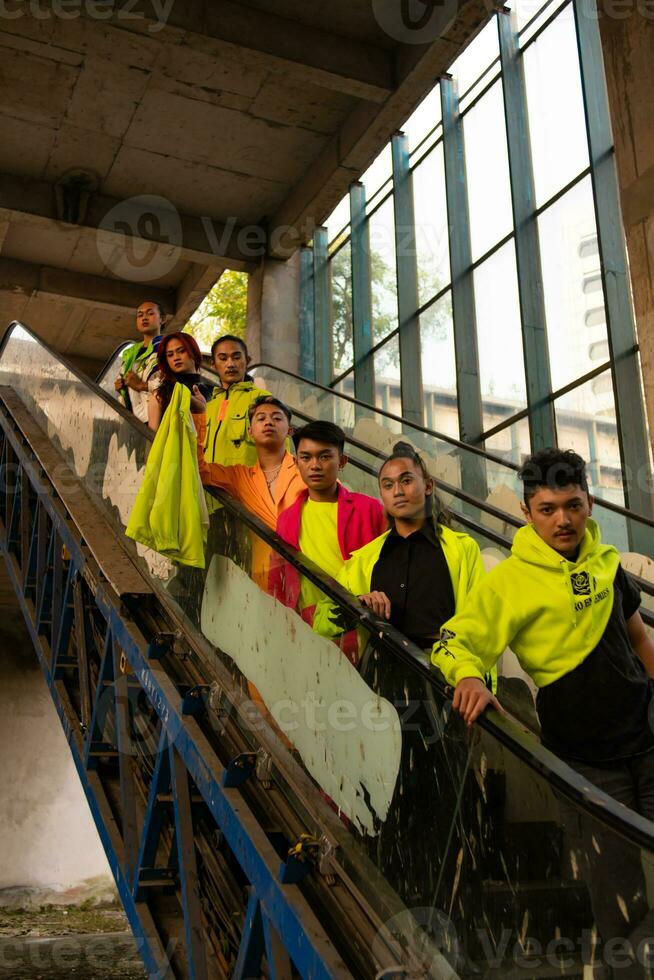 a group of Asian men in green shirts lined up on the stairs in an old building photo