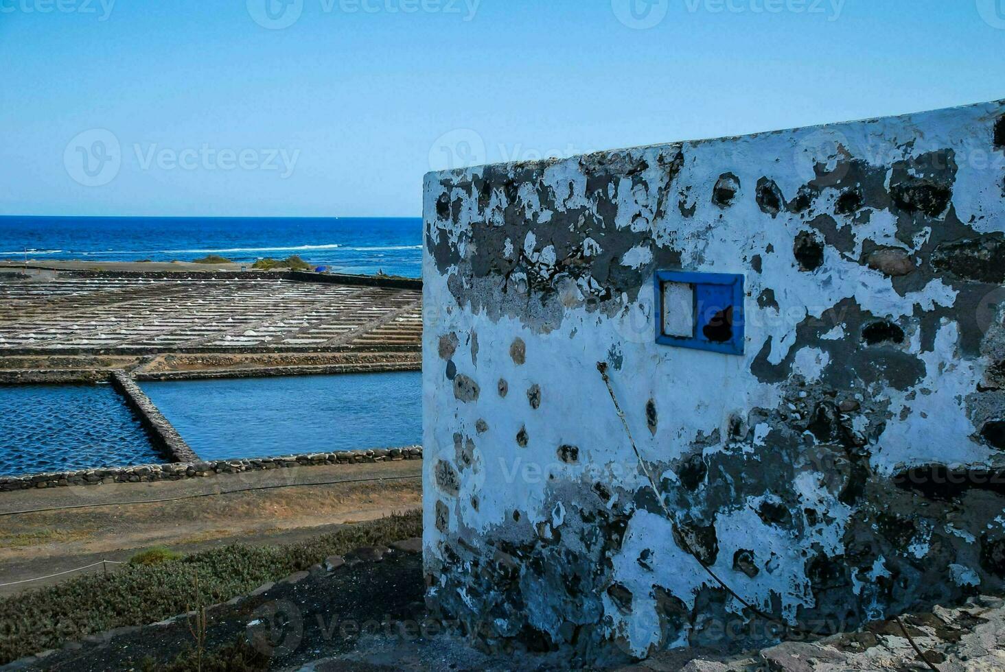 a window in a wall overlooking the ocean photo