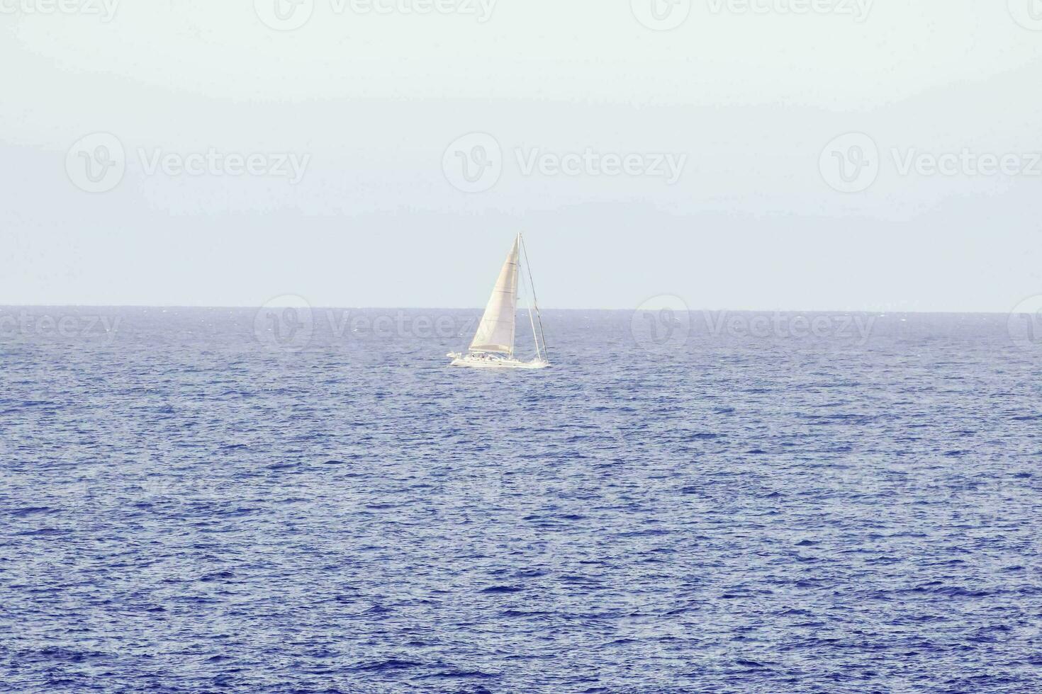 a sailboat is out in the open ocean photo