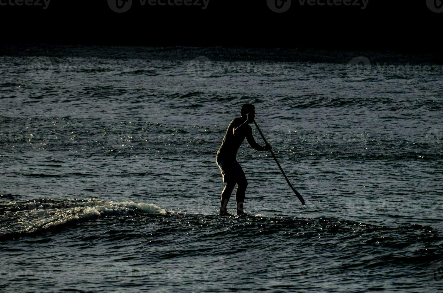 a man on a surfboard in the ocean photo