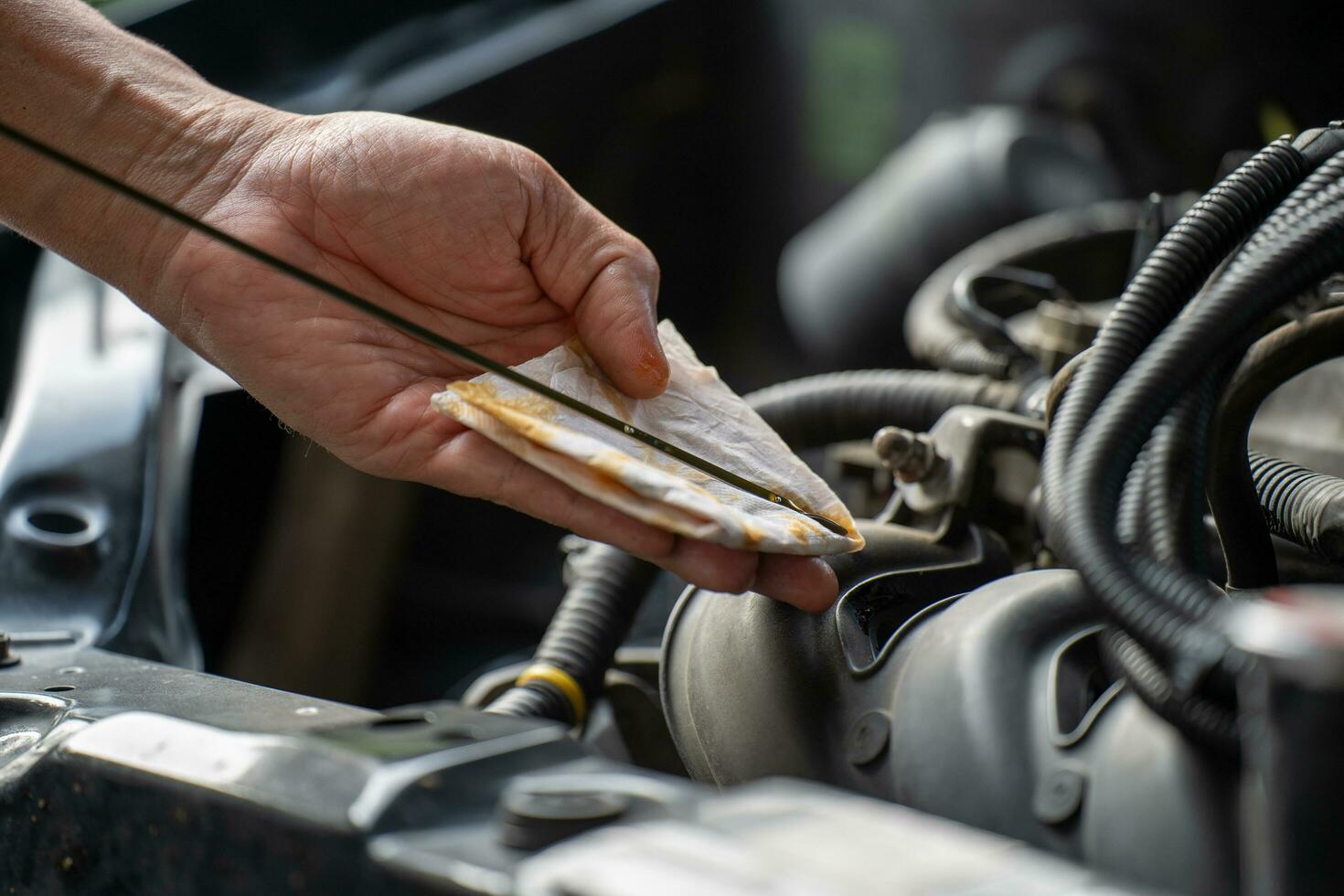 Drivers are Pulling the engine oil level dipstick To check the quality of engine oil. transportation concept photo