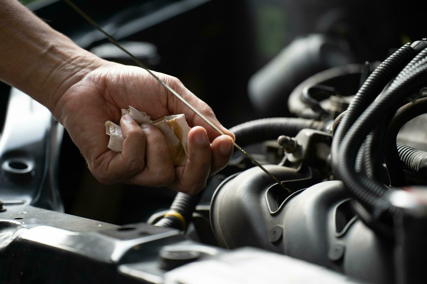 Drivers are Pulling the engine oil level dipstick To check the quality of engine oil. transportation concept photo