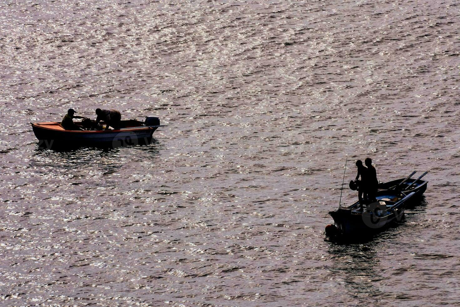 two people in small boats on the water photo