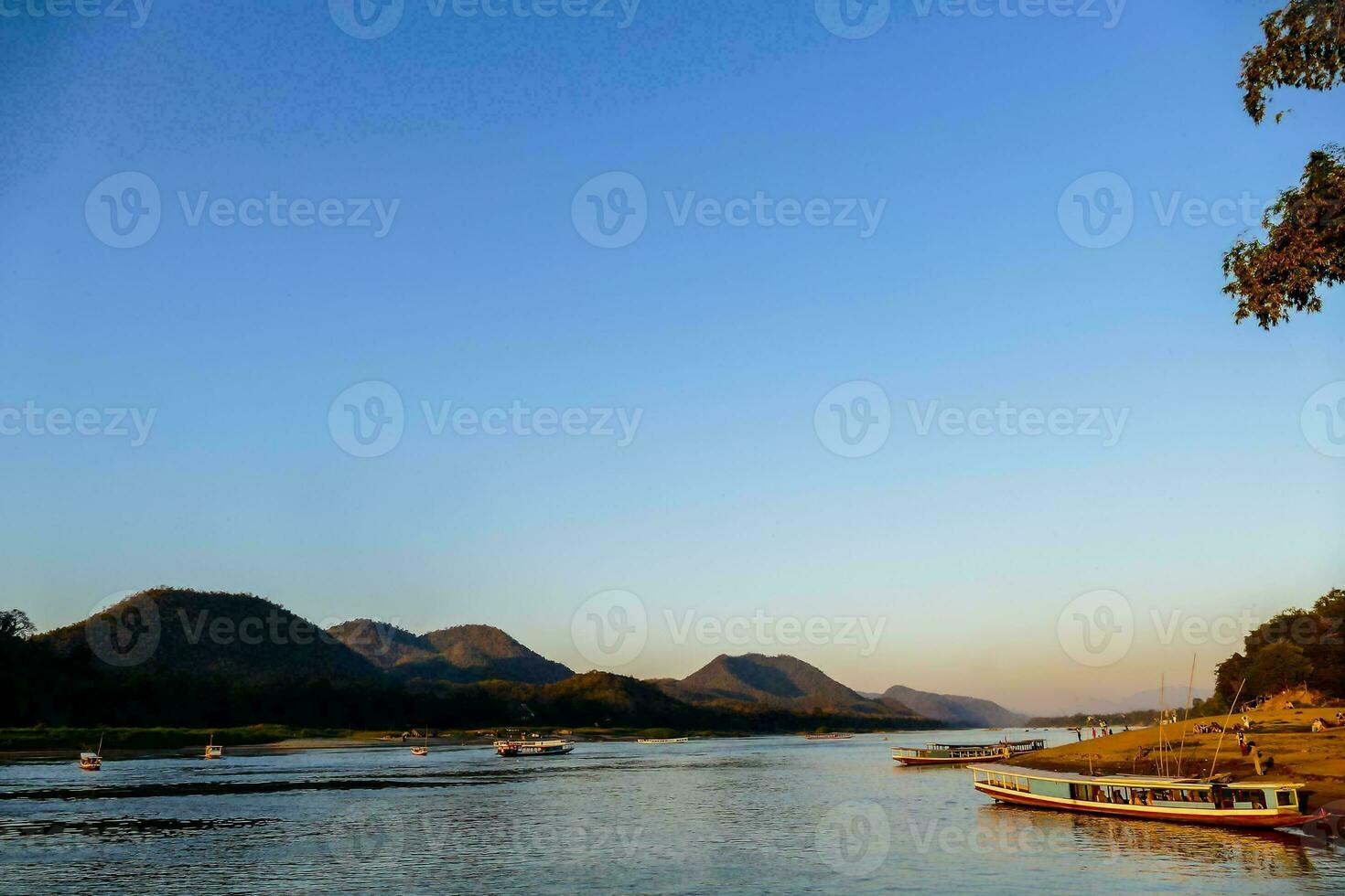 boats on the river with mountains in the background photo