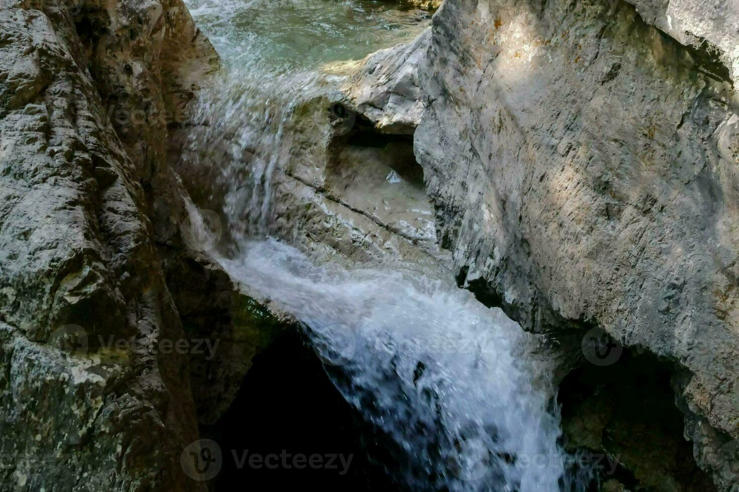 a waterfall flowing through a narrow canyon photo