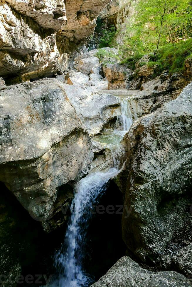 a waterfall flowing through a rocky canyon photo