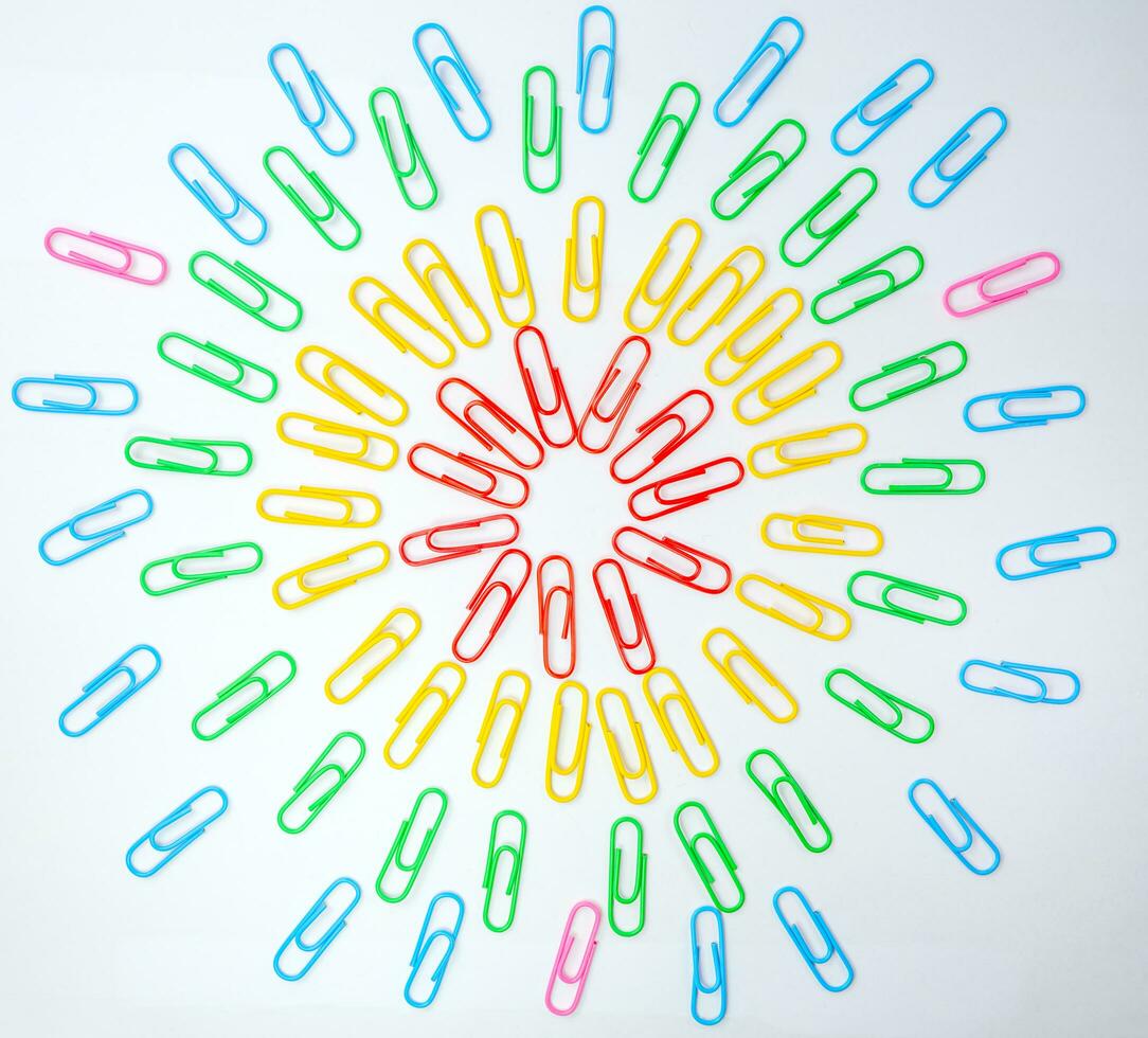 Paper clips, Paper clips multi colored lay in overlapping circles with white background, Office and school supplies concepts, Equipment concept. photo