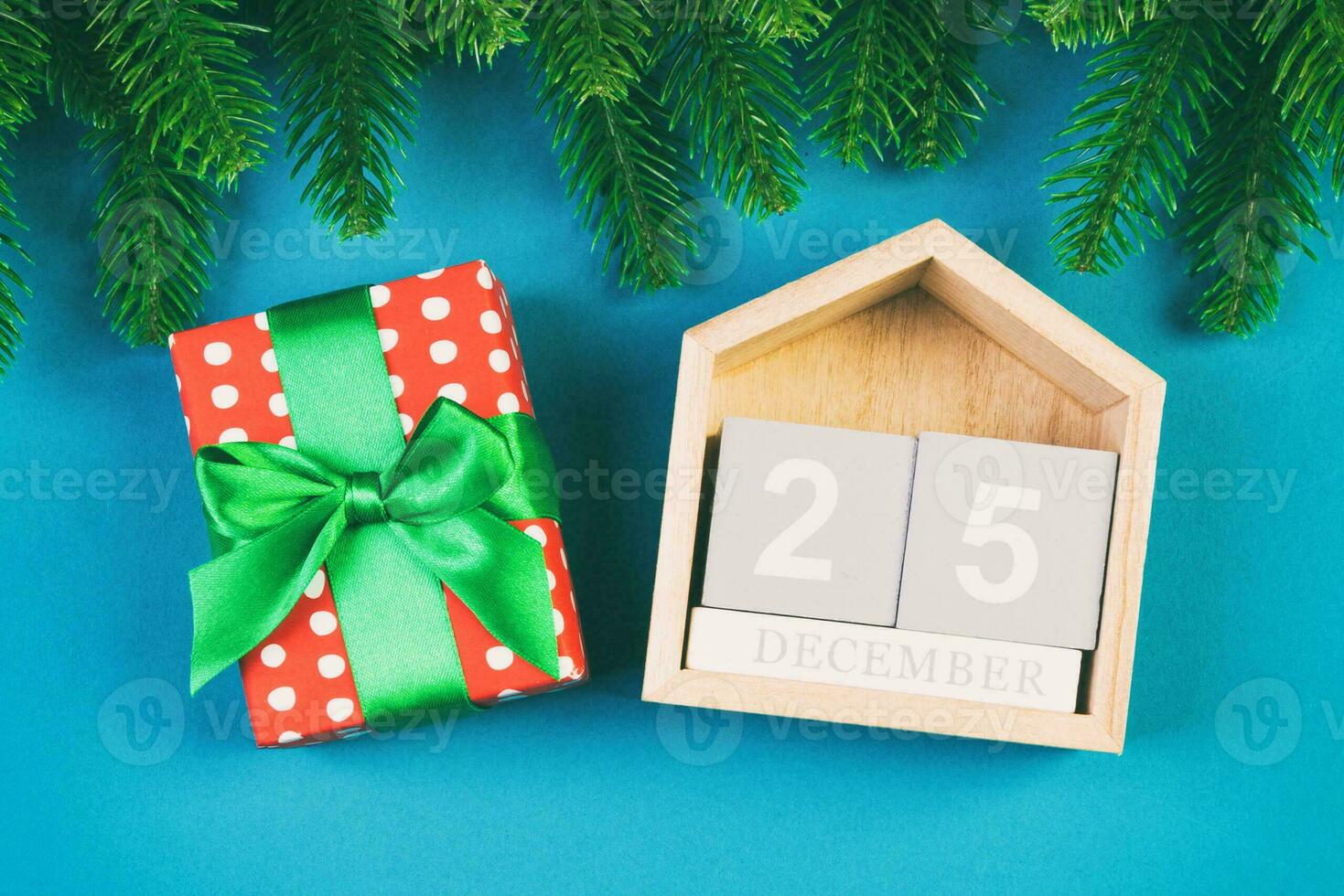 Top view of fir tree, wooden calendar and gift box on colorful background. The twenty fifth of December. Merry Christmas time with empty space for your design photo