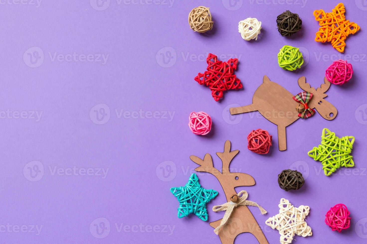 New Year decorations on purple background. Festive stars and balls. Merry Christmas concept with empty space for your design photo