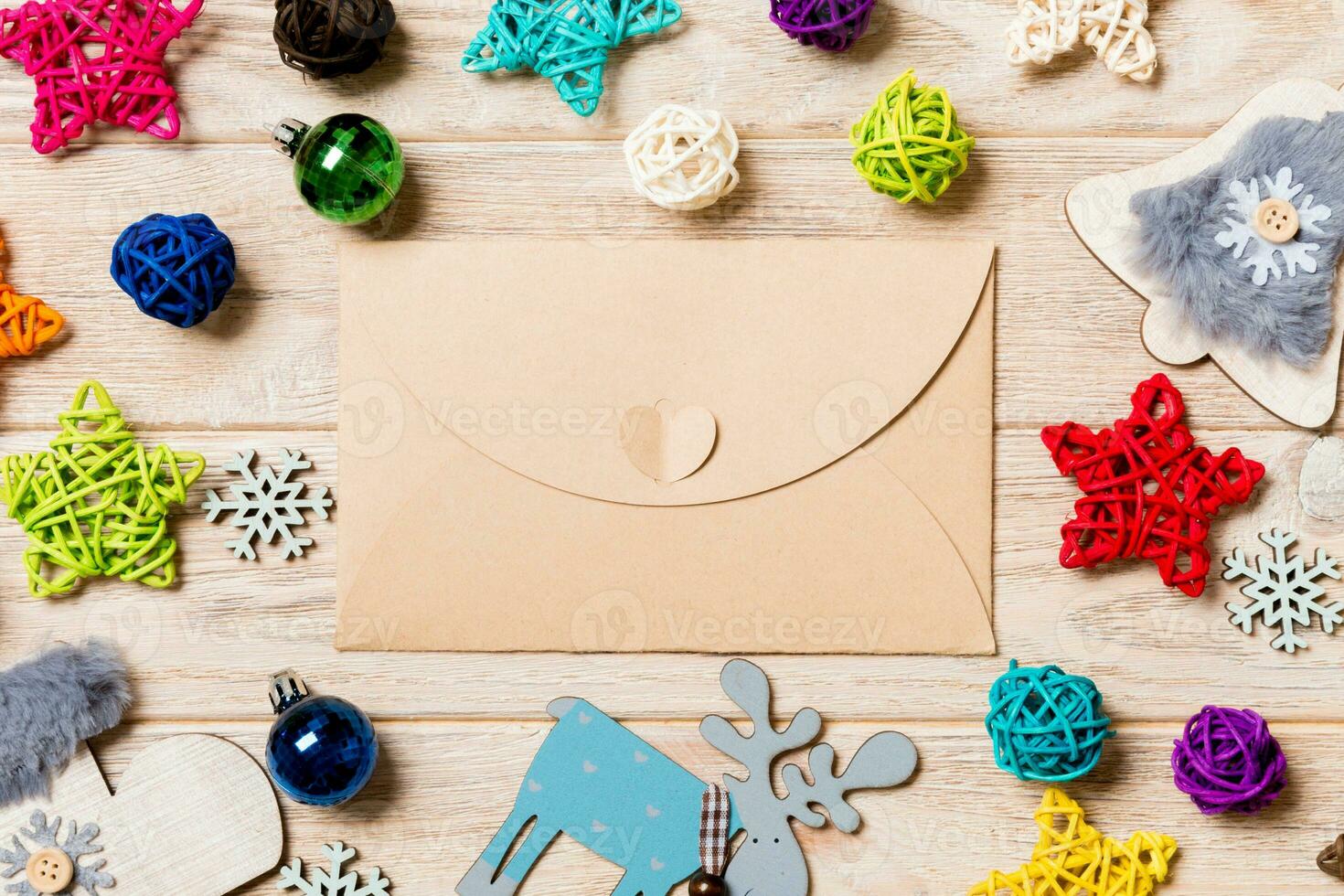 Top view of envelope on festive wooden background. Christmas toys and decorations. New Year time concept photo