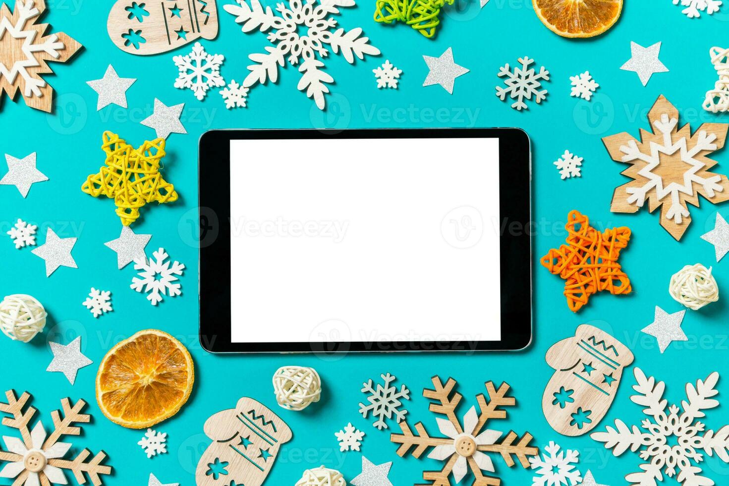 Top view of digital tablet on blue background with New Year toys and decorations. Christmas time concept photo