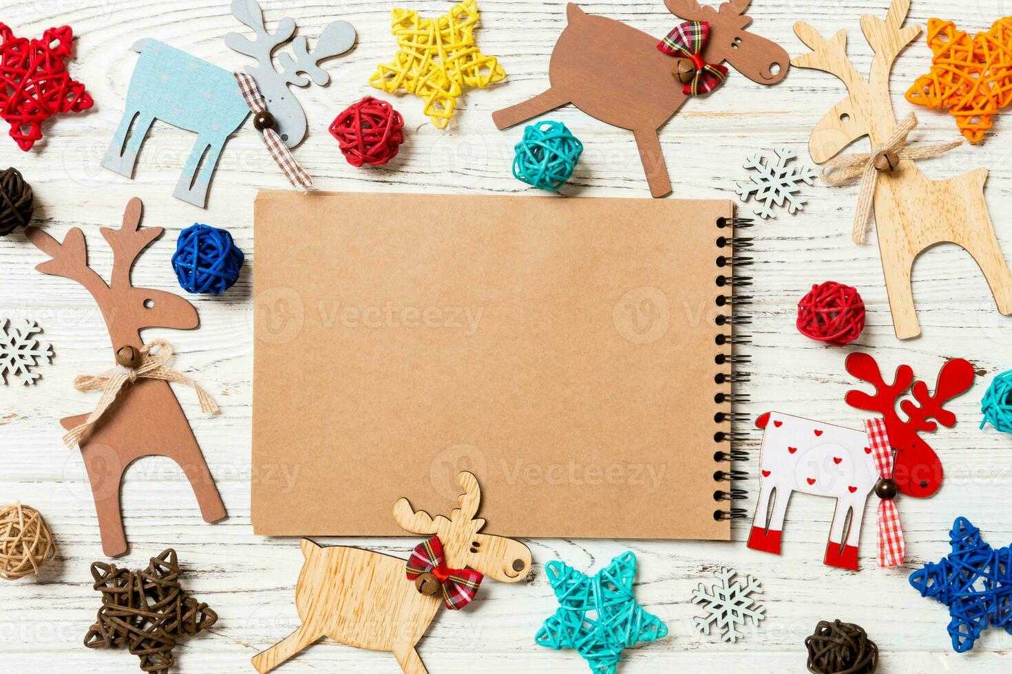 Top view of notebook on wooden background made of Christmas decorations. New Year concept photo