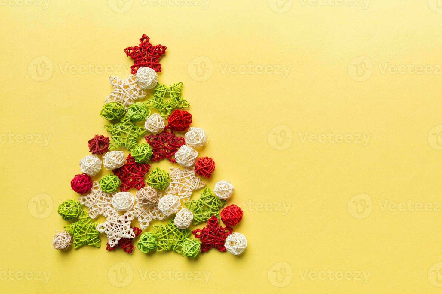 Christmas tree made from colored handmade ball decoration on colored background, view from above. New Year minimal concept with copy space photo