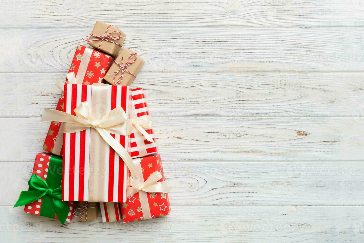Christmas tree made of beautifuly wrapped presents on colored background, view from above. New Year gift box minimal concept with copy space photo