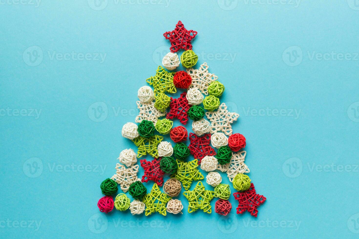 Christmas tree made from colored handmade ball decoration on colored background, view from above. New Year minimal concept with copy space photo