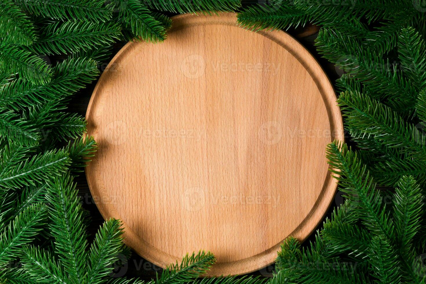 Top view of wooden plate decorated with fir tree branches. New Year dinner concept with empty space for your design photo
