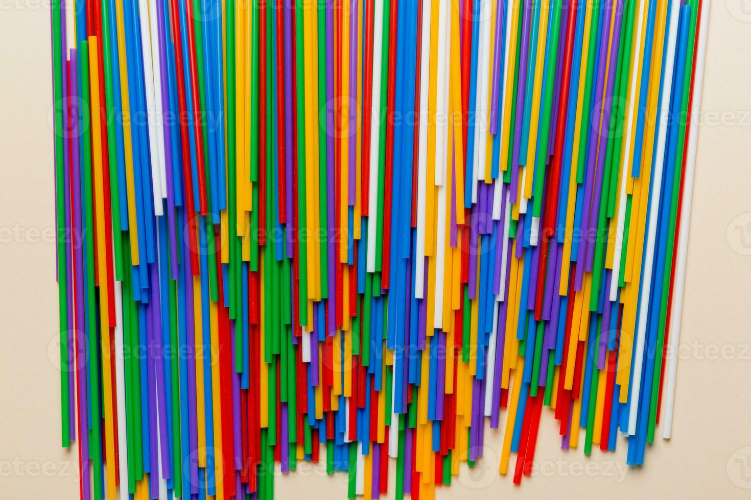 many multi-colored plastic tubes for cocktail on Colored background, top view photo