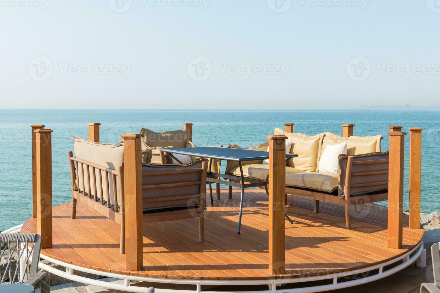 Beautiful terrace with table, sofas and armchair. Great sea view photo