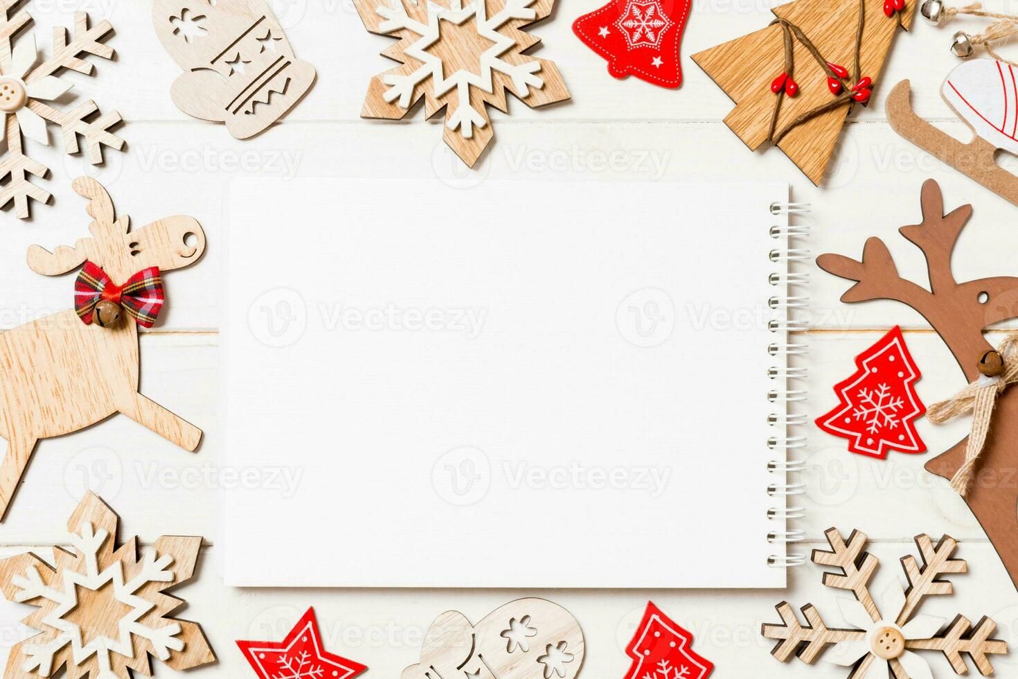 Top view of notebook on wooden background made of Christmas decorations. New Year concept photo