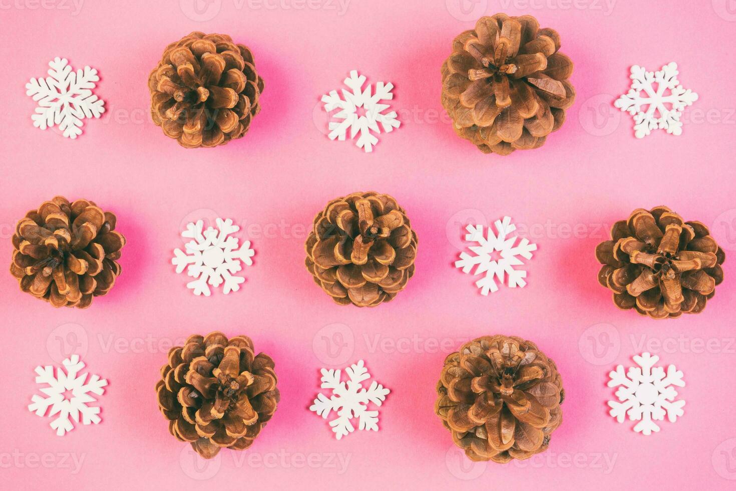 Top view of holiday composition made of pine cones and white snowflakes on colorful background. Winter time and Christmas concept with copy space photo