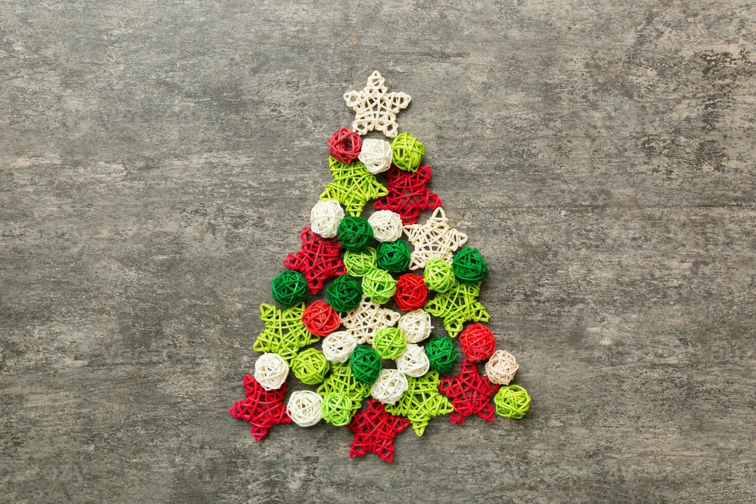 Christmas tree made from colored handmade ball decoration on colored background, view from above. New Year minimal concept with copy space photo