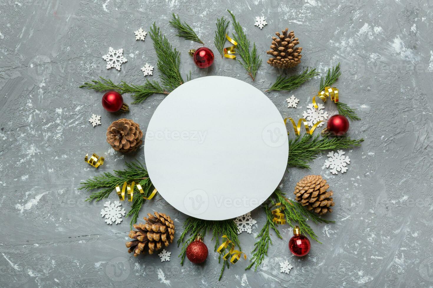 Flat lay Christmas composition. Round Paper blank, pine tree branches, christmas decorations on Colored background. Top view, copy space for text photo