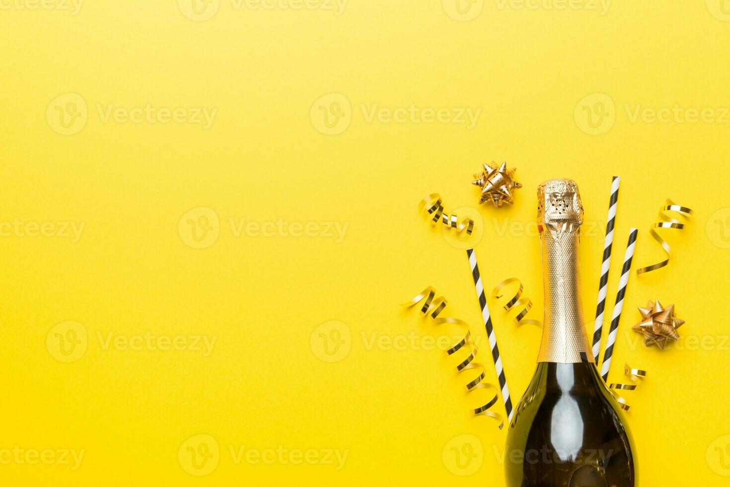 bottle of champagne with glasses and colorful confetti on colored background. top view flay lay photo