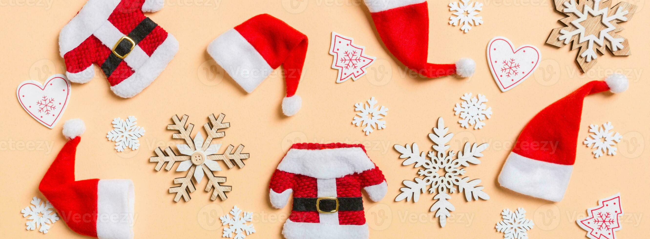 Top view Banner of Christmas decorations and Santa hats on orange background. Happy holiday concept photo