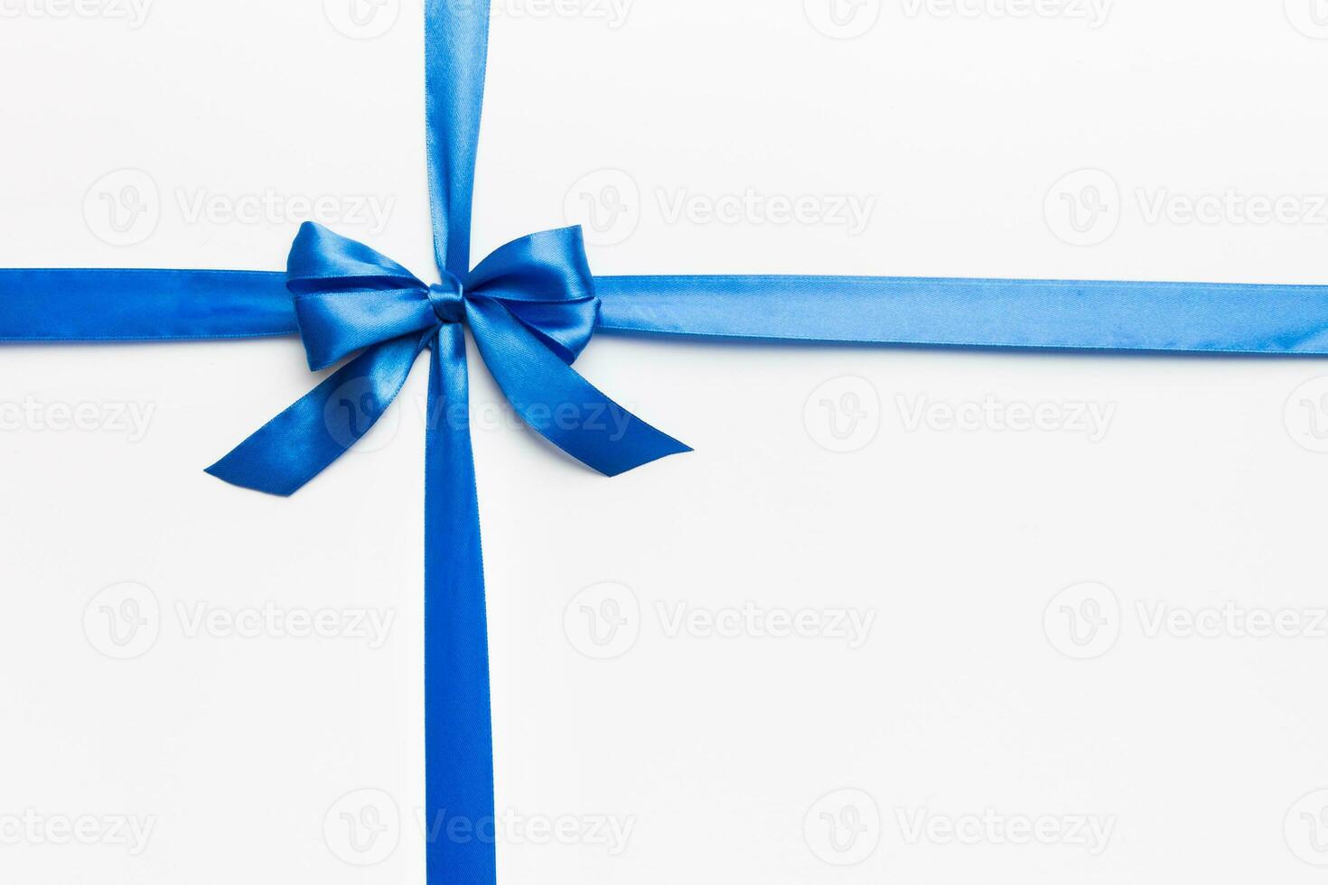 Top view of blue ribbon rolled and blue bow isolated on colored background. Flat lay with copy space photo