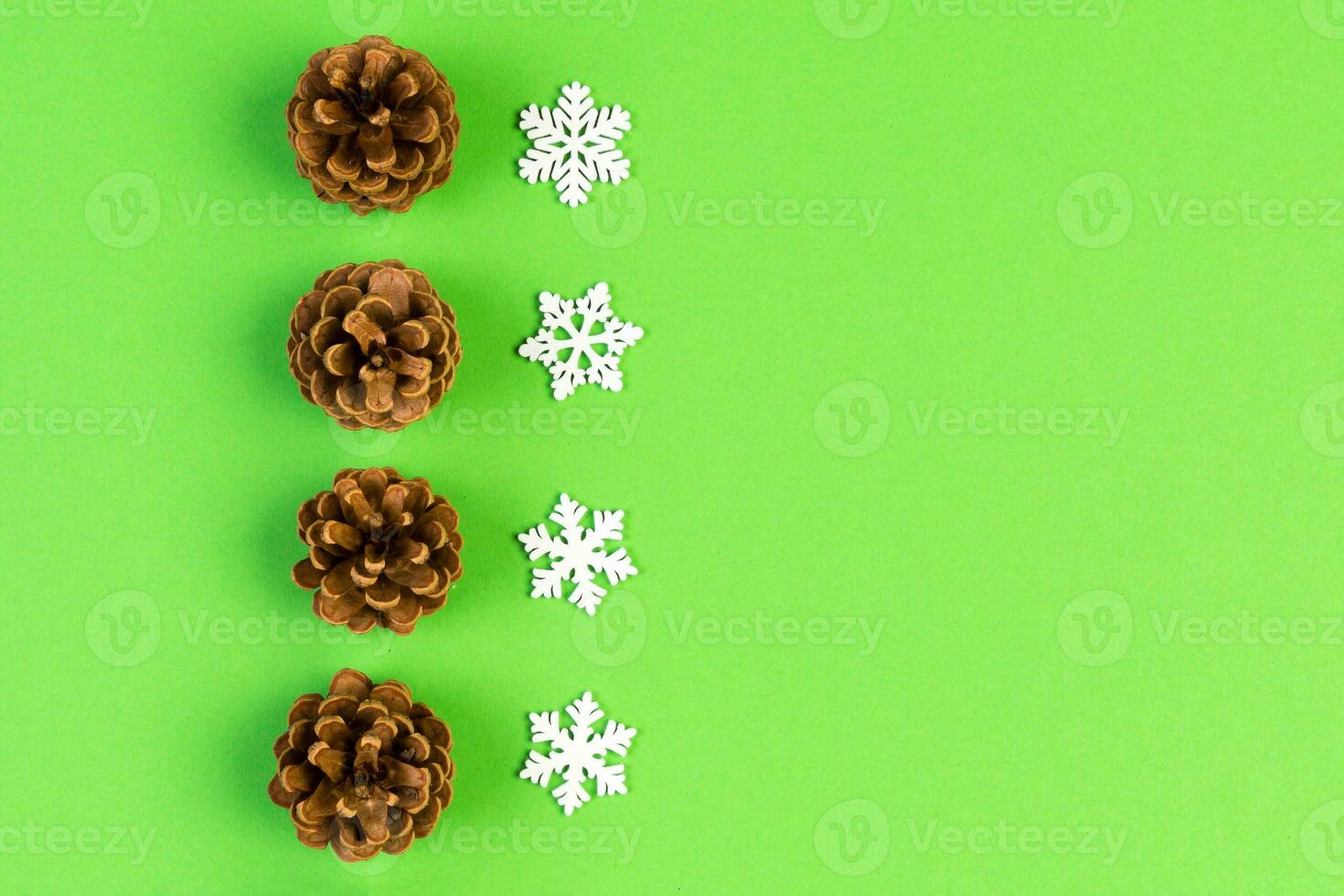 Top view of New Year ornament made of white snowflakes and pine cones on colorful background. Winter holiday concept with empty space for your design photo