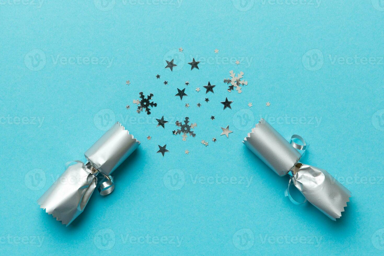 Christmas crackers with shiny confetti on color background, top view, copy space photo