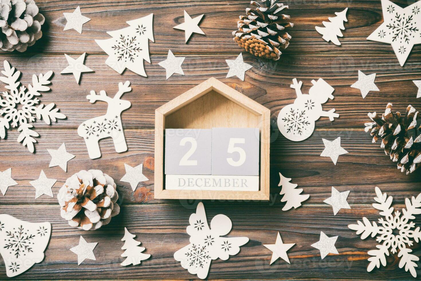 Top view of calendar on Christmas wooden background. The twenty fifth of December. New Year toys and decorations. Holiday concept photo