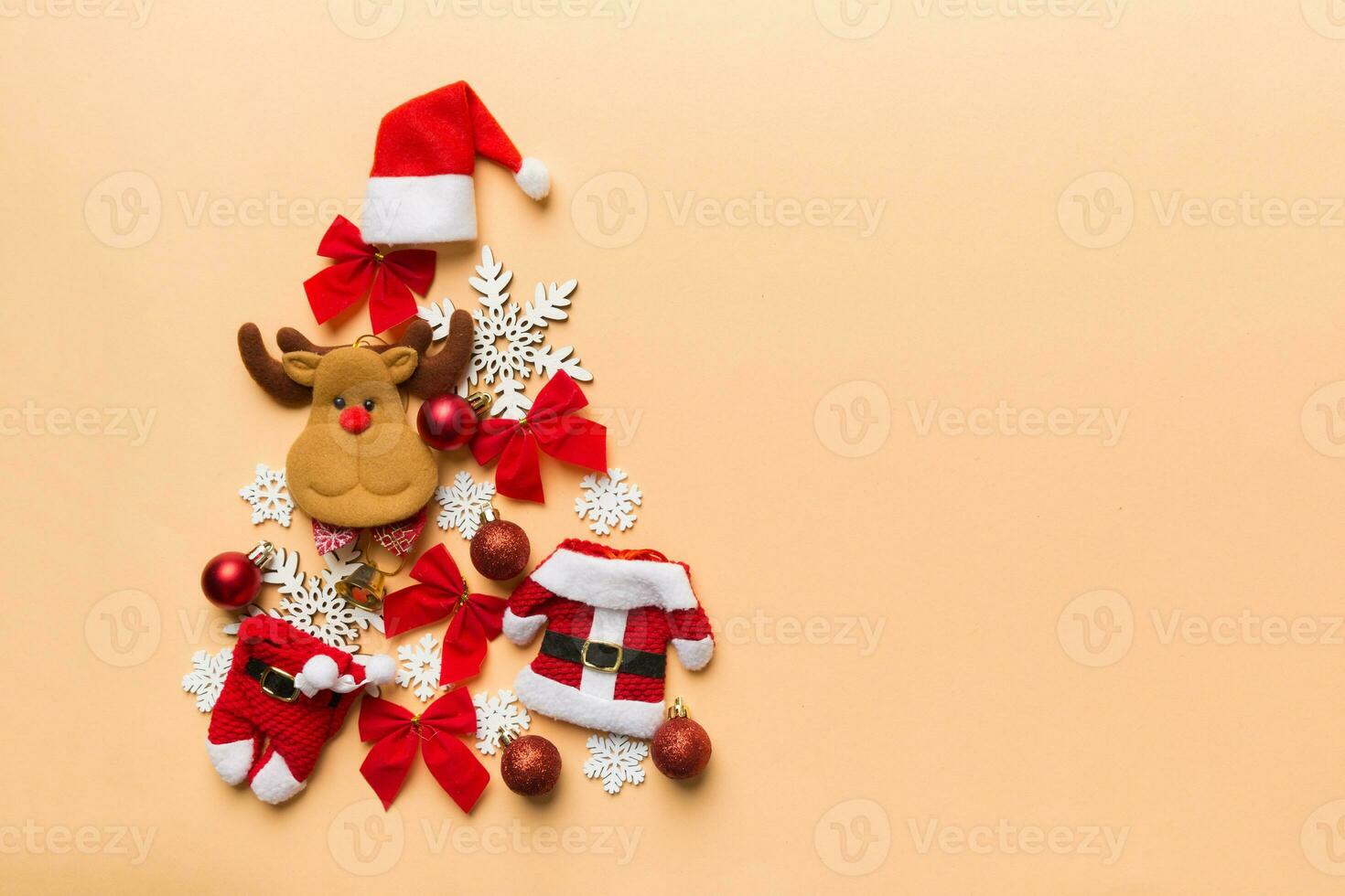 Christmas tree made from colored suit santa decoration on colored background, view from above. New Year minimal concept with copy space photo