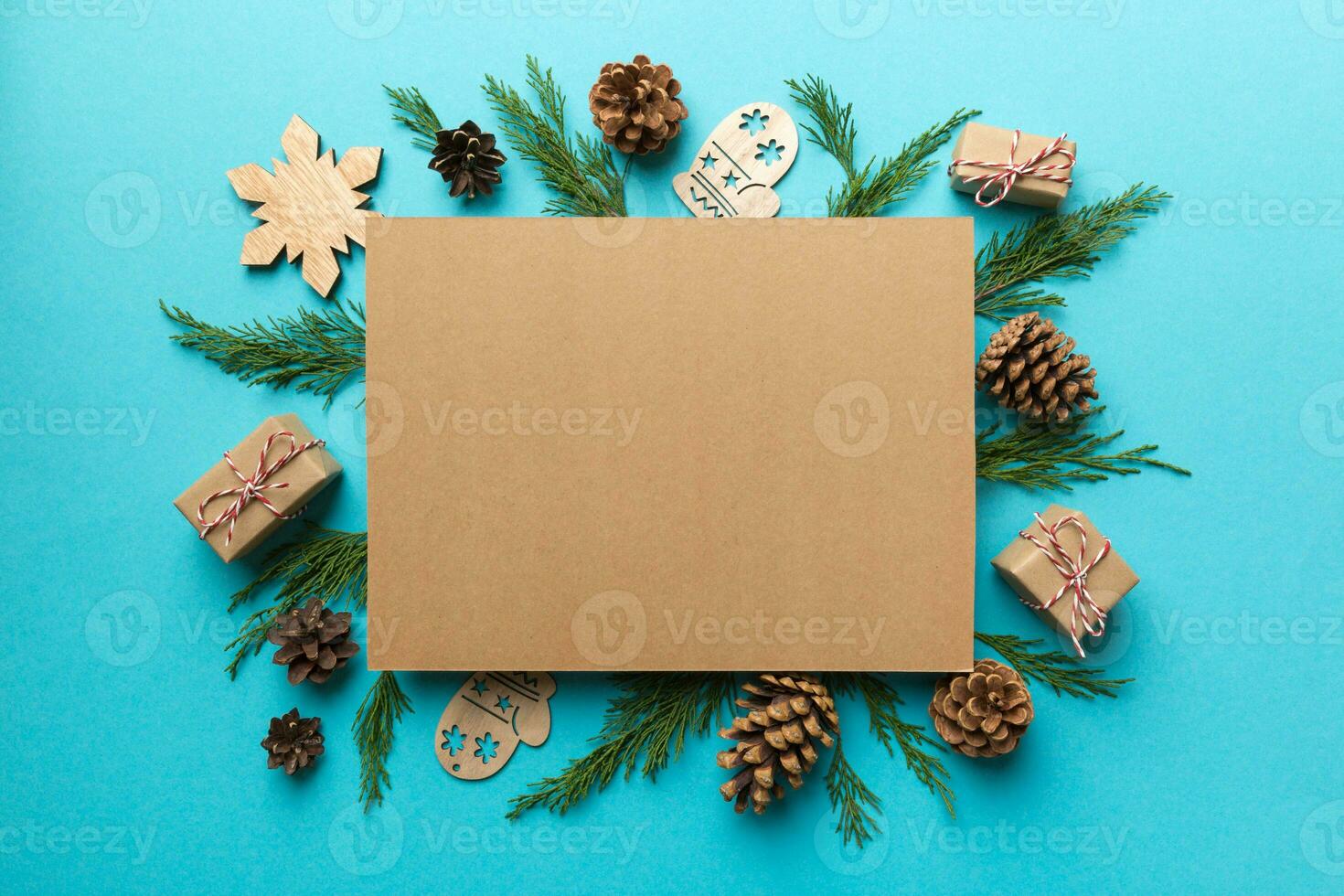 Flat lay Christmas composition. square Paper blank, pine tree branches, christmas decorations on Colored background. Top view, copy space for text photo