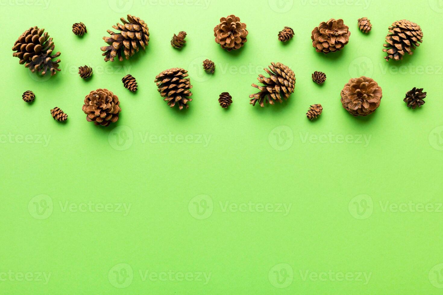 Christmas pine cones on colored paper border composition. Christmas, New Year, winter concept. Flat lay, top view, copy space photo