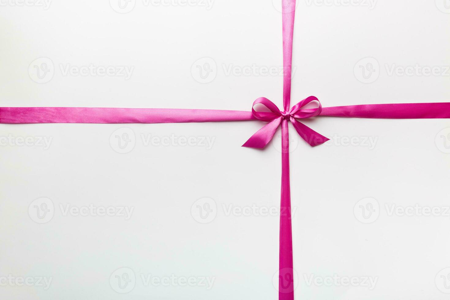 Top view of purple ribbon rolled and pink bow isolated on colored background. Flat lay with copy space photo
