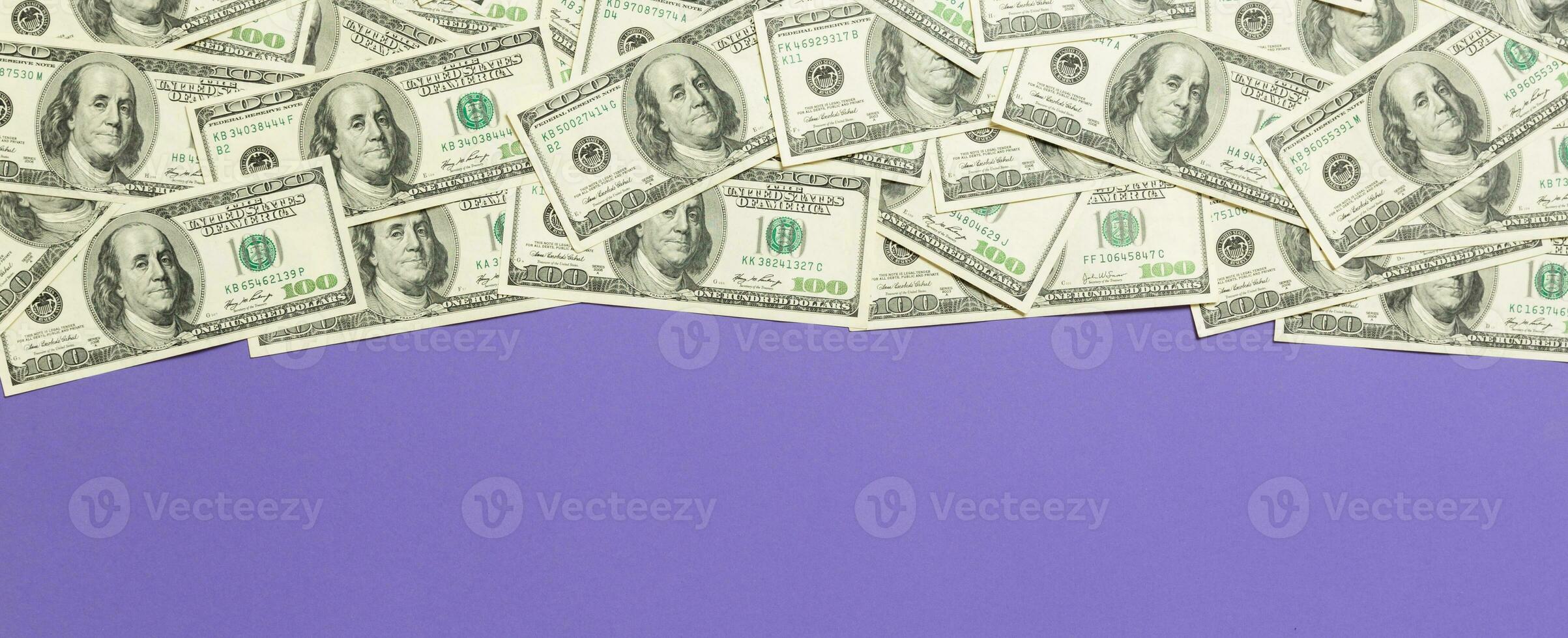 Top view banknotes on colored desk with copy space on top. one hundred dollar bills with stack of money in the middle. Top view of business concept photo