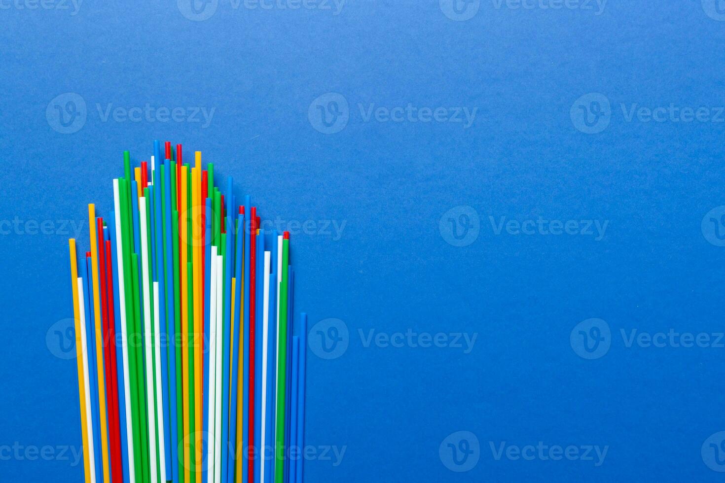 Heap of colorful plastic drinking straws on Colored background, flat lay. Copy Space for text photo