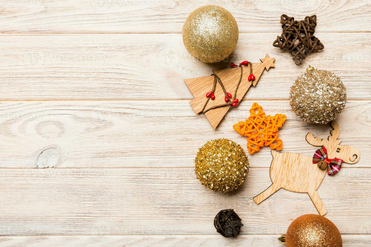 New Year composition made of baubles, reindeer and other decorations on wooden background. Christmas time concept with empty space for your design photo