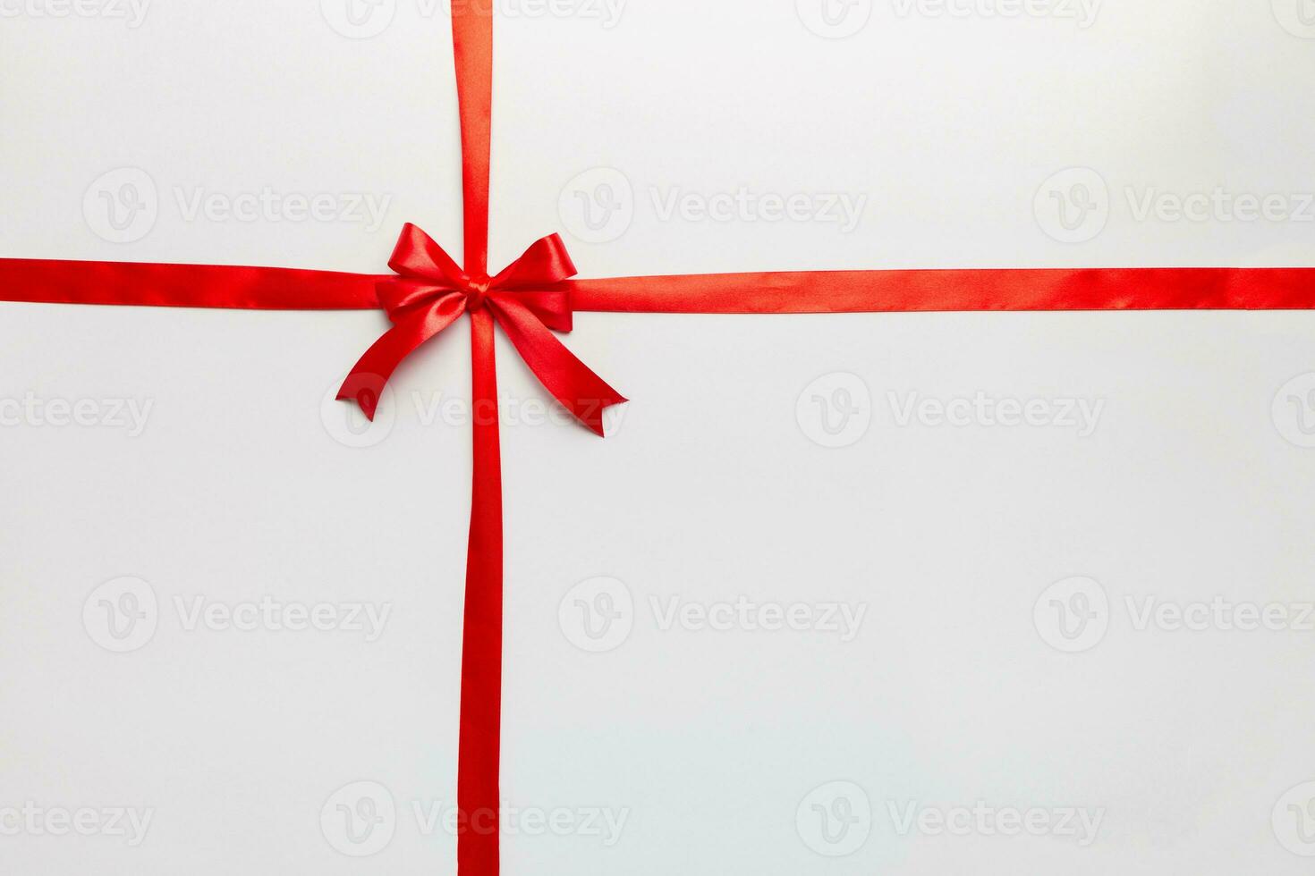 Top view of Red ribbon rolled and red bow isolated on colored background. Flat lay with copy space photo