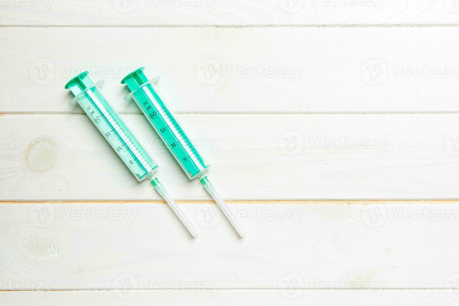 Top view of syringes on wooden background with copy space. Medical equipment for injection concept photo