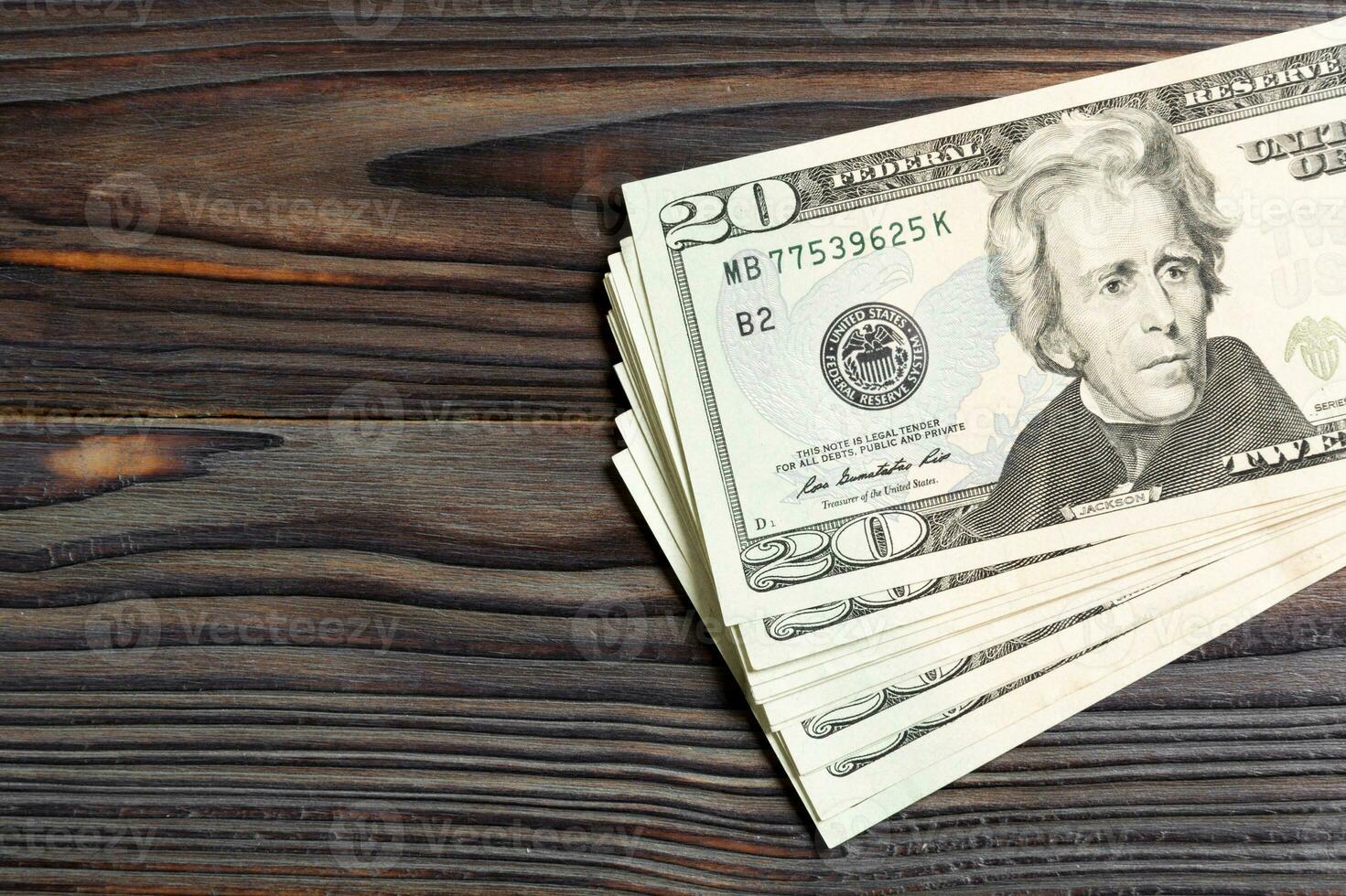 Top view of bundle of 20 dollar bill on wooden backgound. Business concept with copy space photo