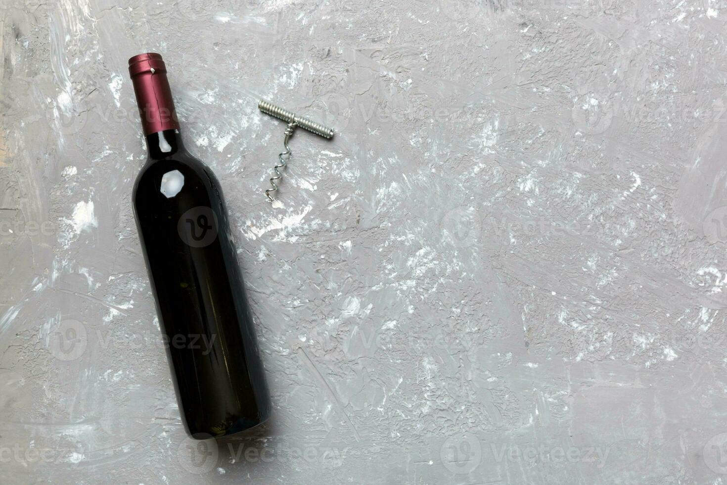 One Bottle of red wine with corkscrew on colored table. Flat lay, top view wth copy space photo