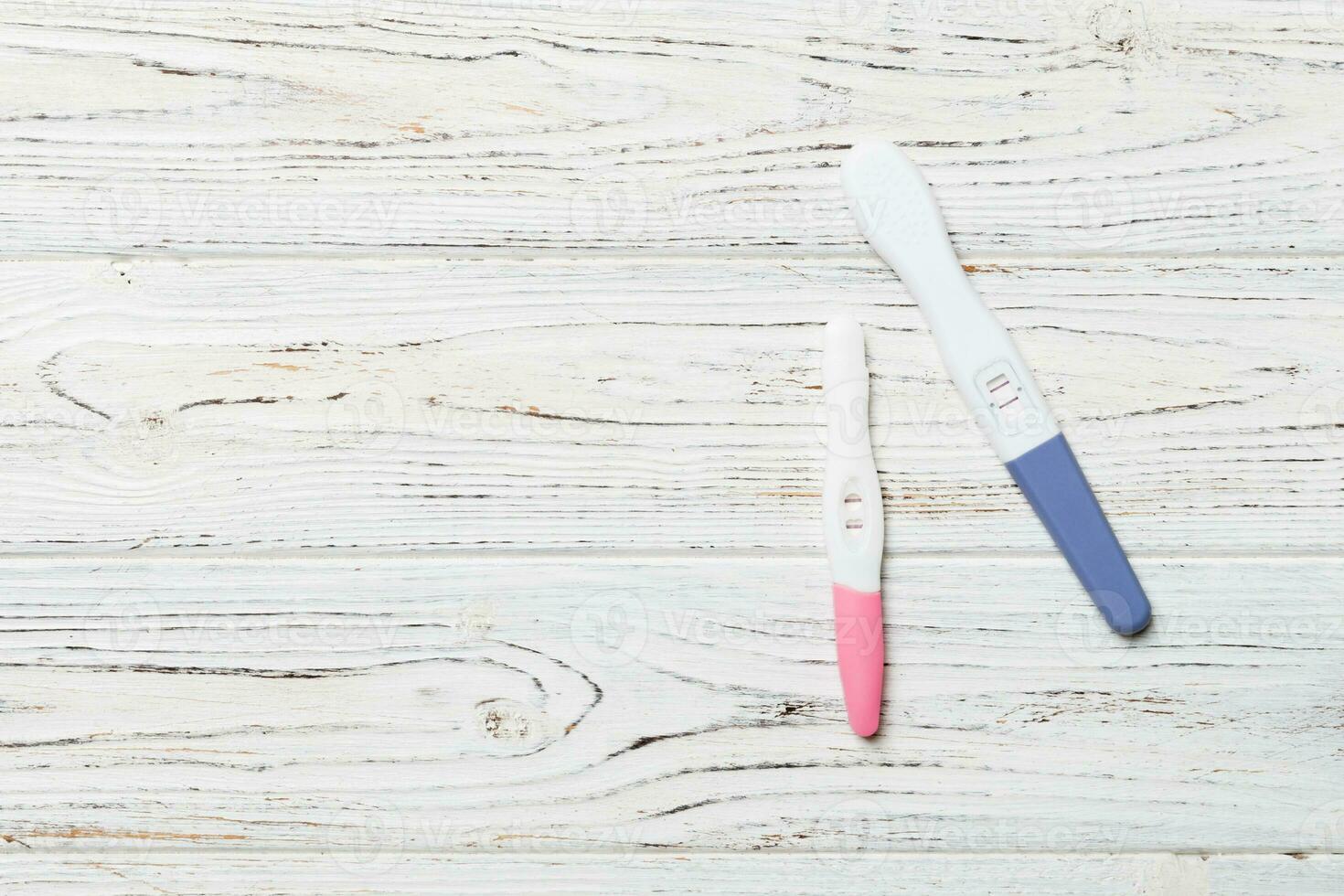 Colored Pregnancy test on wooden background, top view with copy space photo