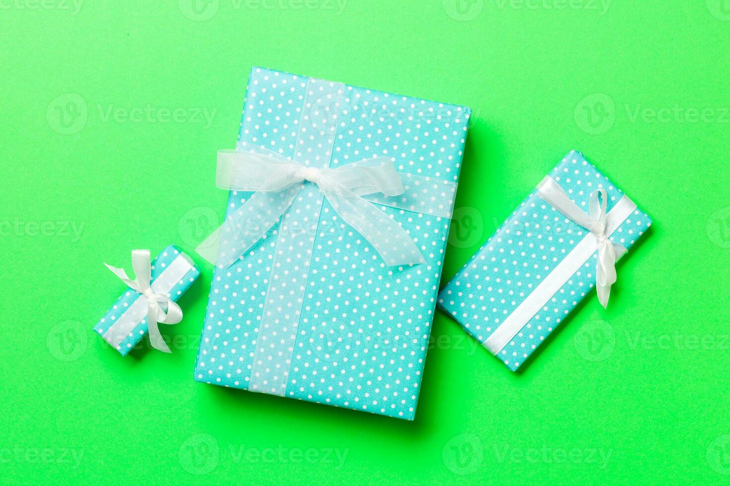 Top view Christmas present box with white bow on green background photo