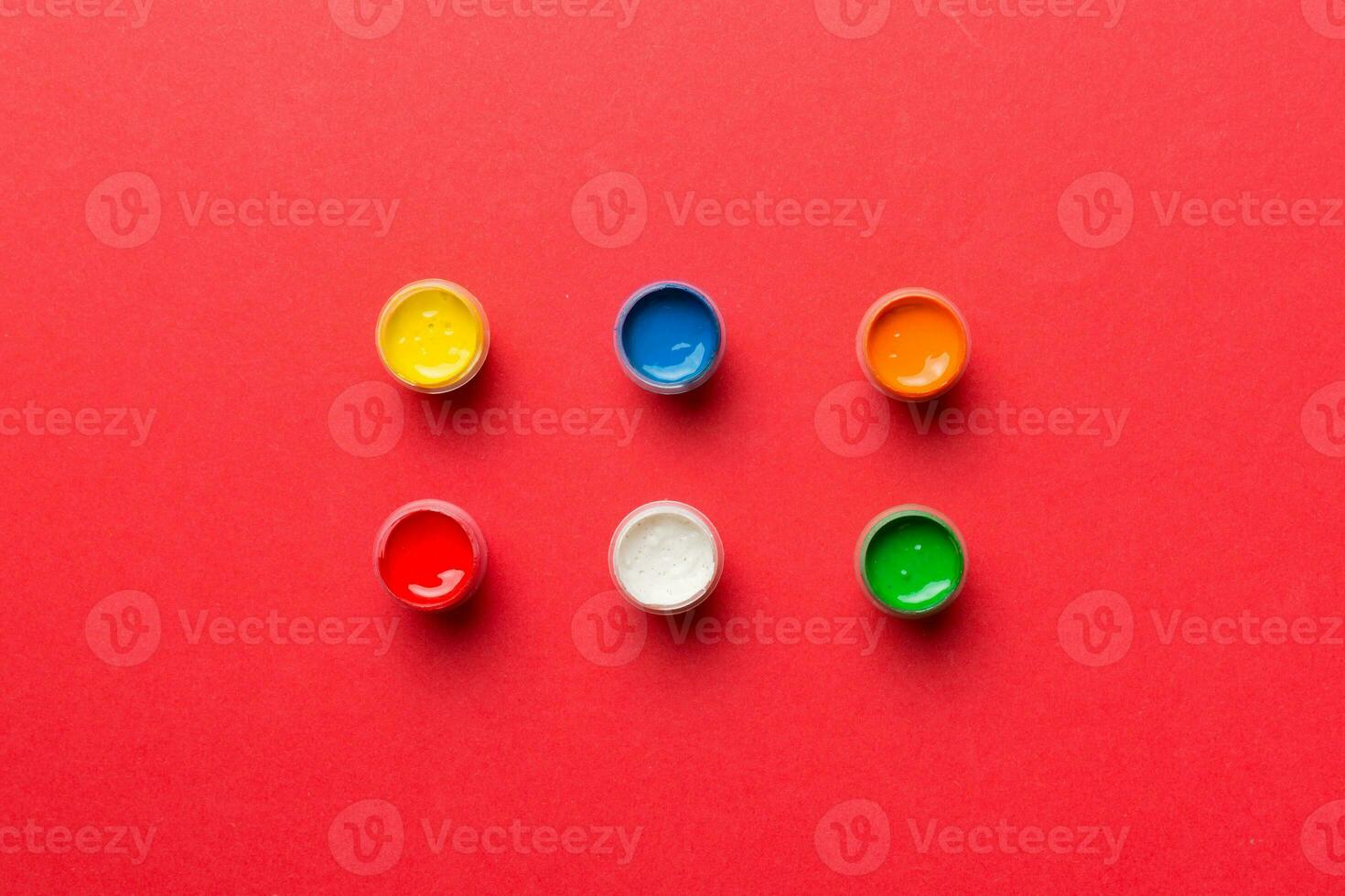 jars with gouache of different colors on Colored background. hobby painting. Top view with empty space. workplace for creativity. home teaching concept drawing photo
