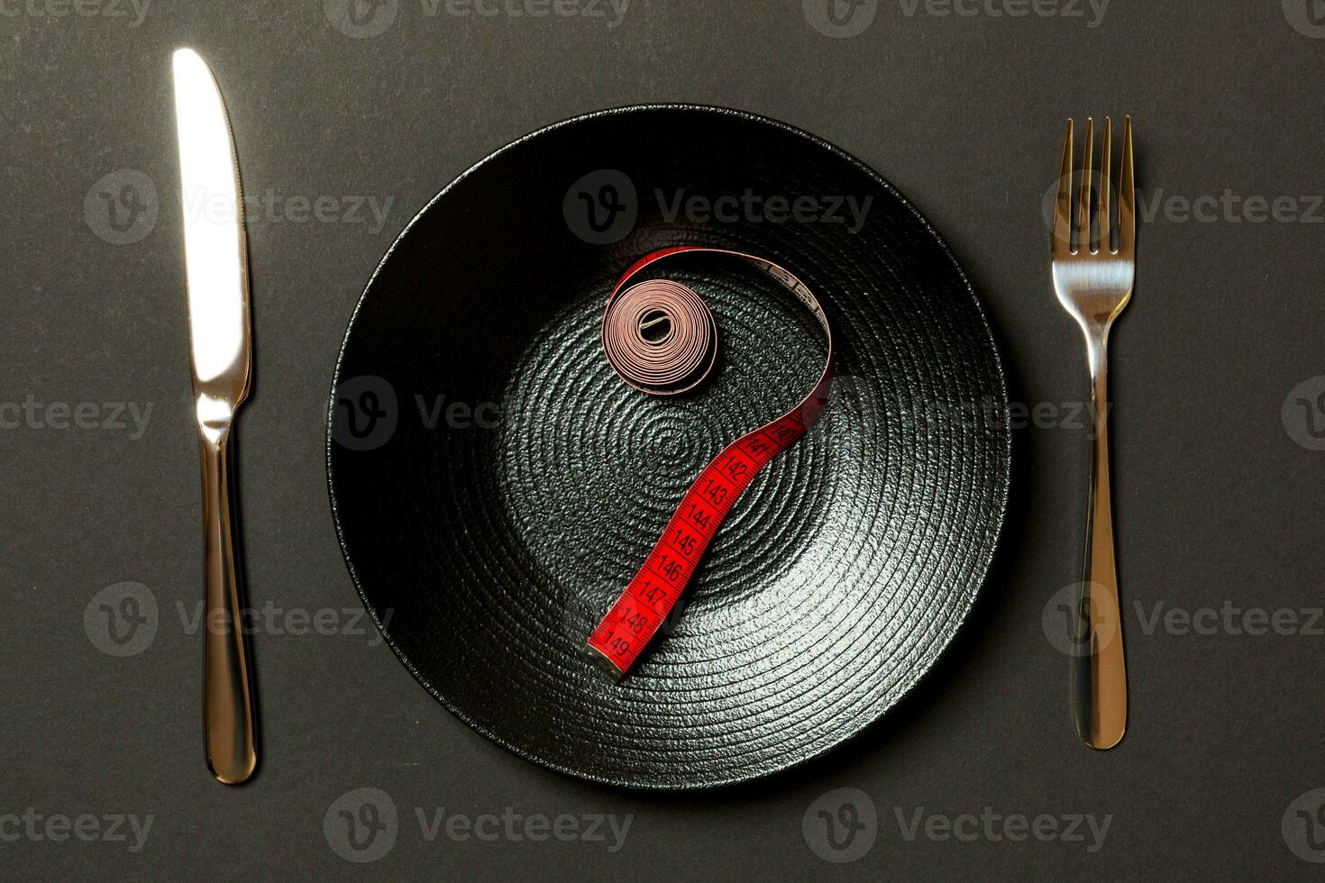 Fork and plate with measuring tape on color background. Diet concept photo